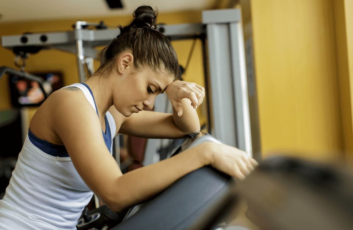 woman at gym hand to head
