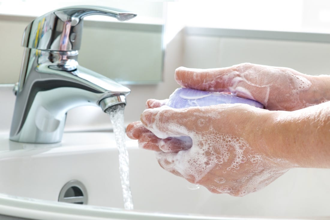 Soapy hands under sink