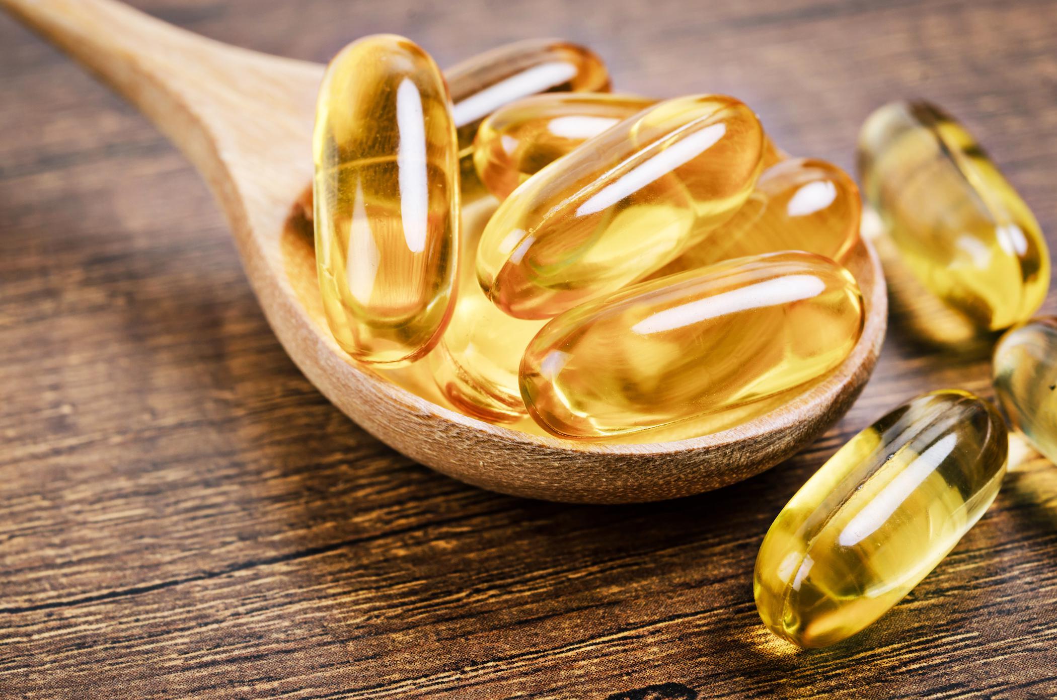 fish oil pills wooden spoon